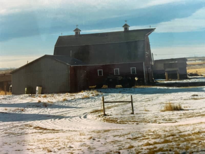 Old red barn surrounded by snow