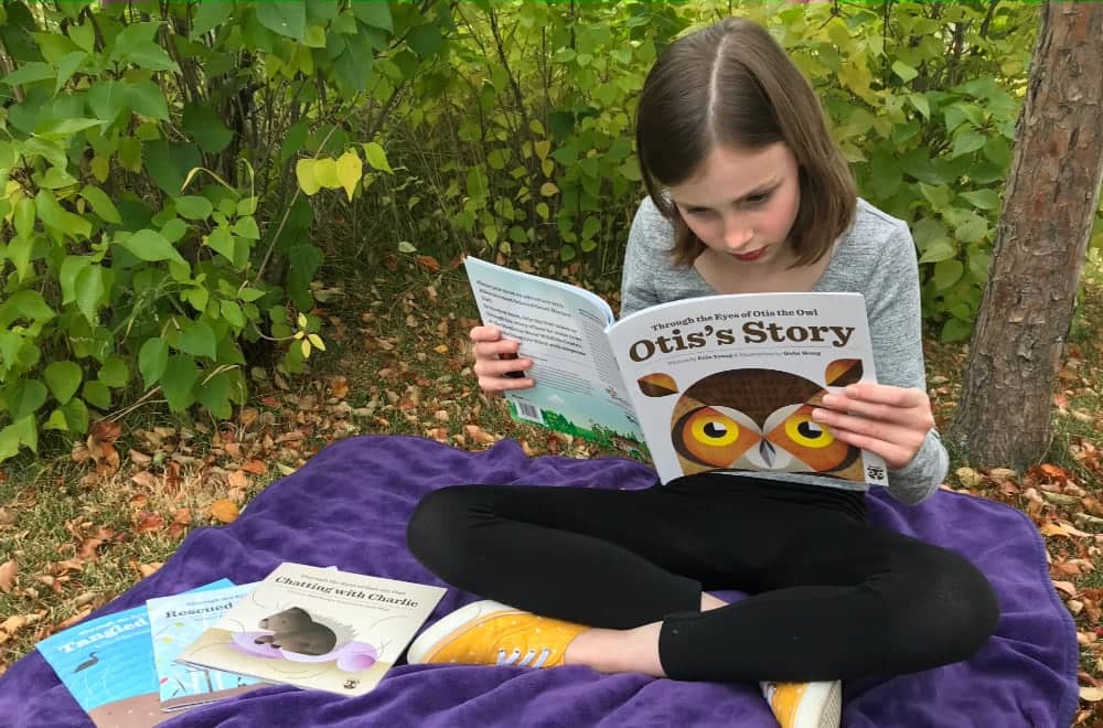 Child reading book about owls