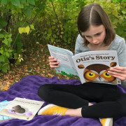 Child reading book about owls
